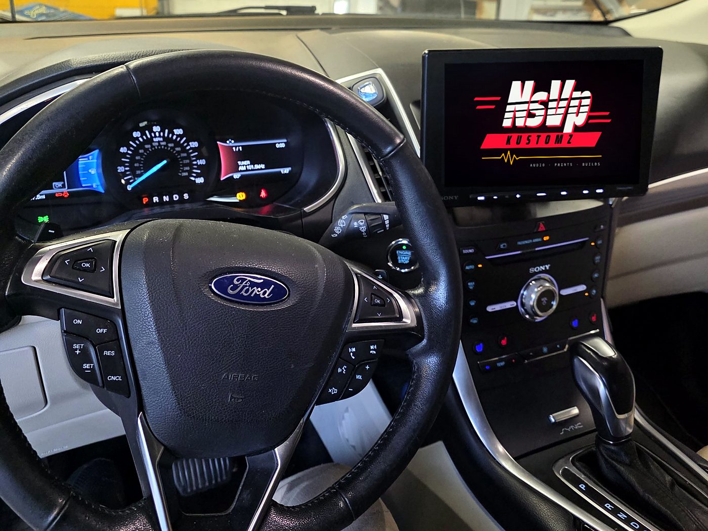 Driver's view of a 2017 Ford Edge with a Sony XAV-AX8500 floating screen mounted above the factory controls
