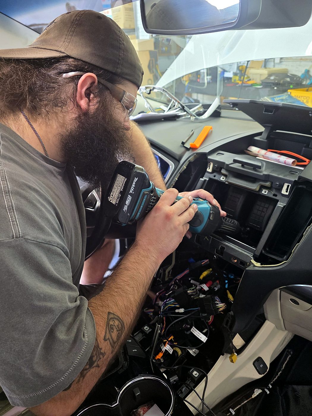 Zach driving screws into the radio mounting bracket in the Ford Edge dash