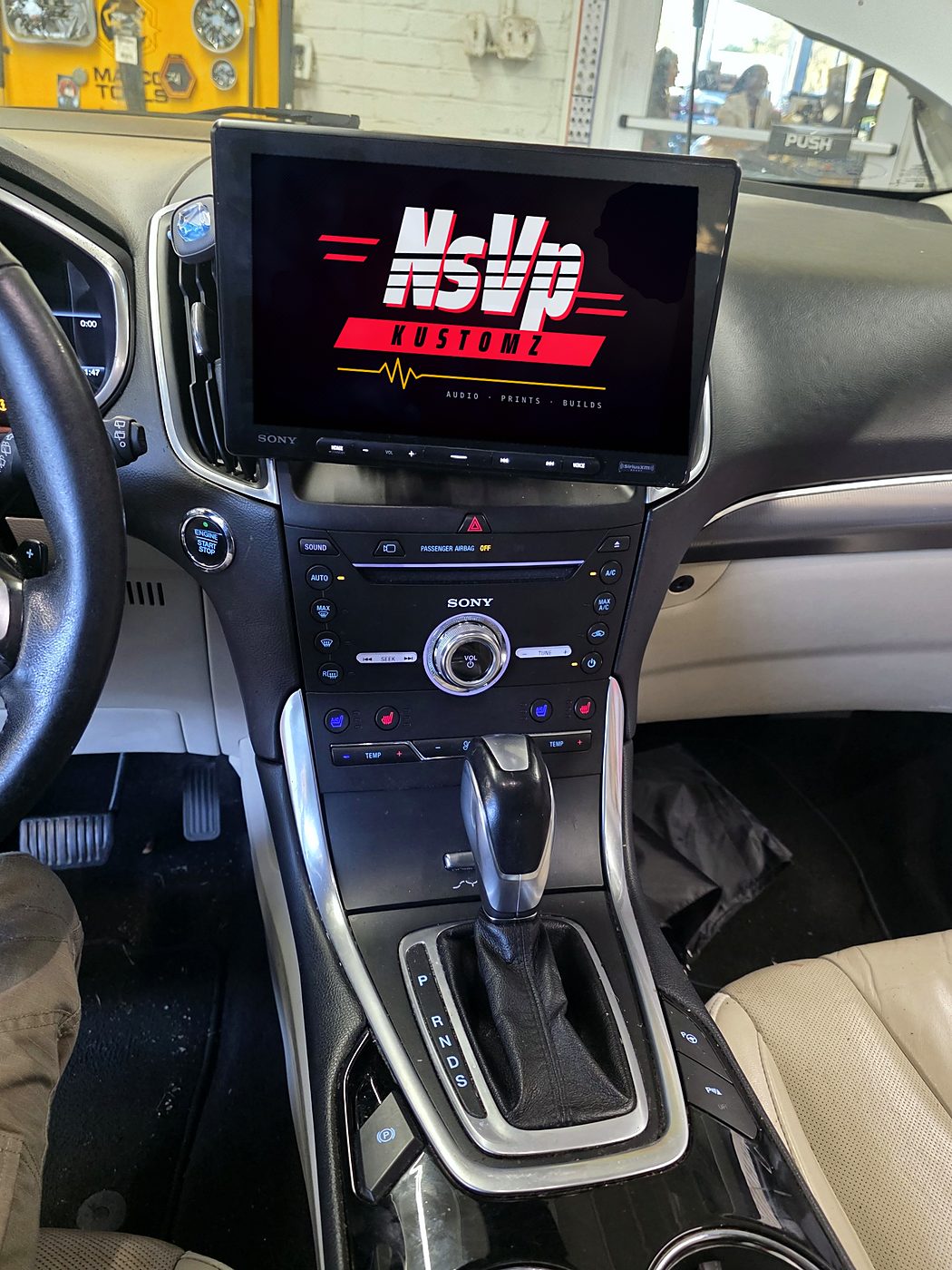 Center stack of the Ford Edge with the Sony floating-screen radio above the factory climate controls