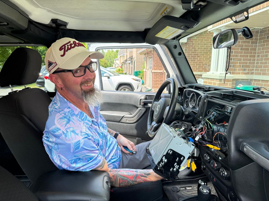Paul installing a head unit in a Jeep