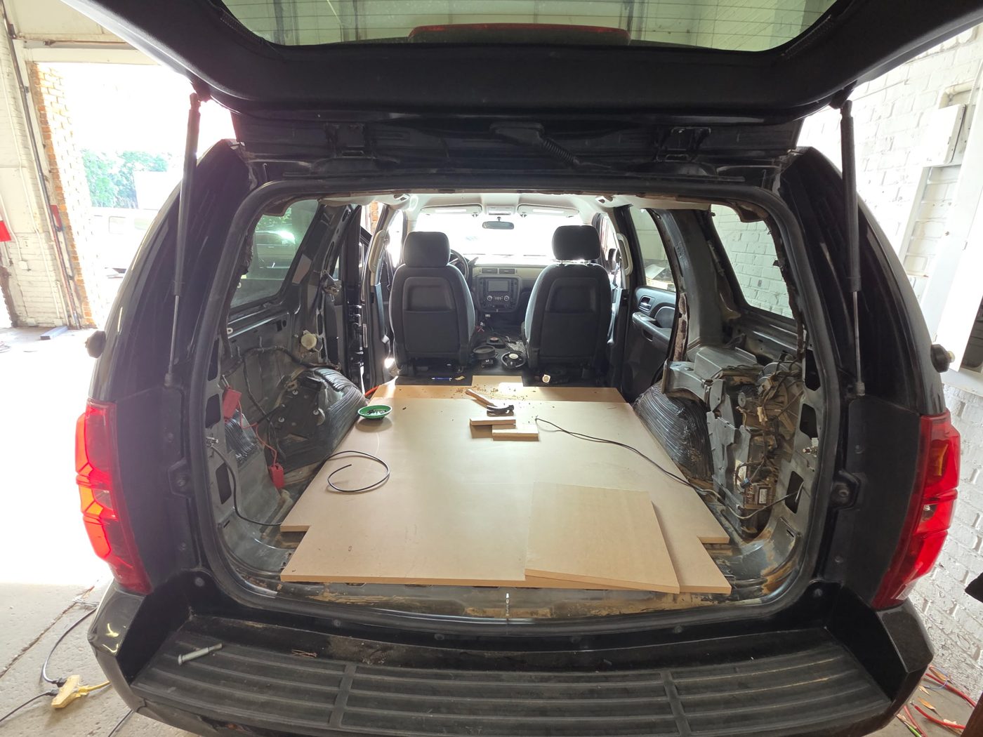 Tahoe cargo area stripped with the rear seats out and new MDF flooring going down