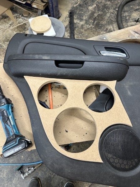 Door panel with an MDF speaker board cut for several speakers