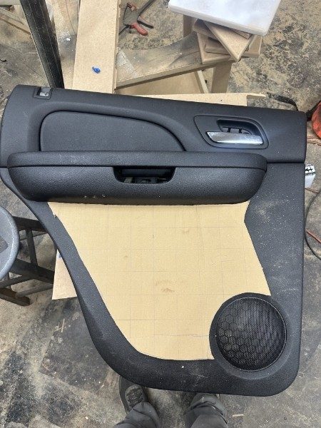 Rear door panel with a cardboard template for the new speaker panel