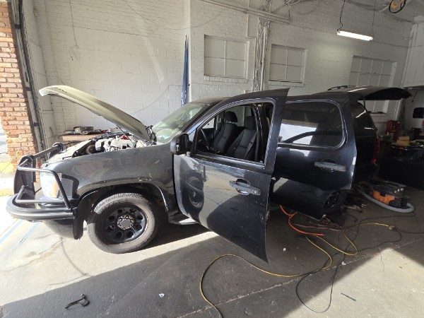 Black 2012 Chevy Tahoe in the shop bay with the doors and hood open