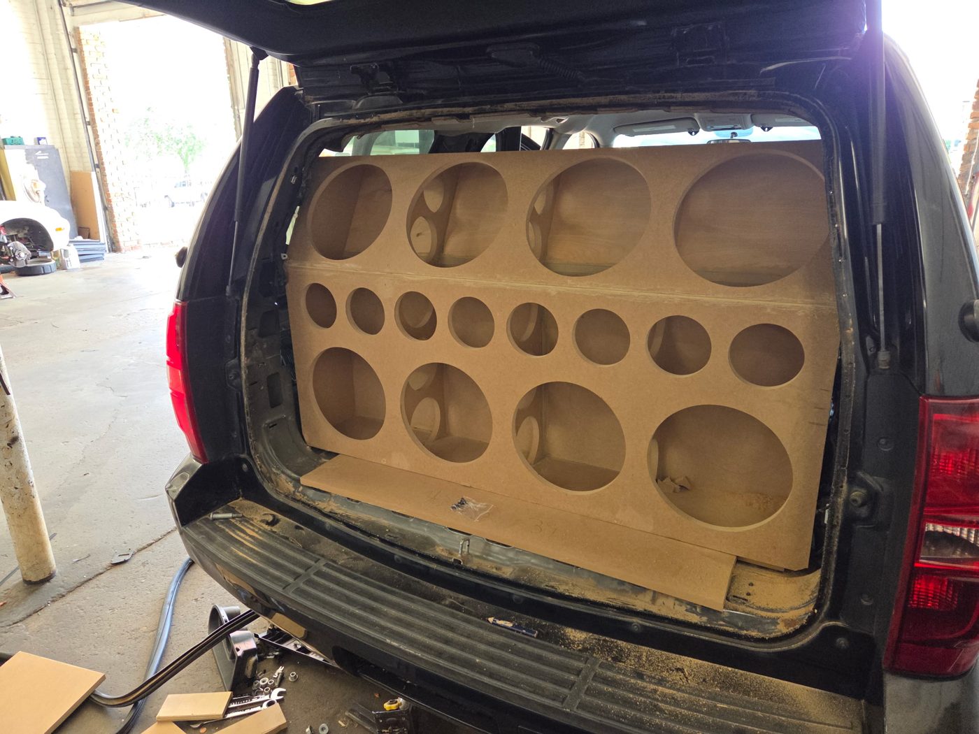MDF baffle in the Tahoe's rear hatch with eight large and eight small openings