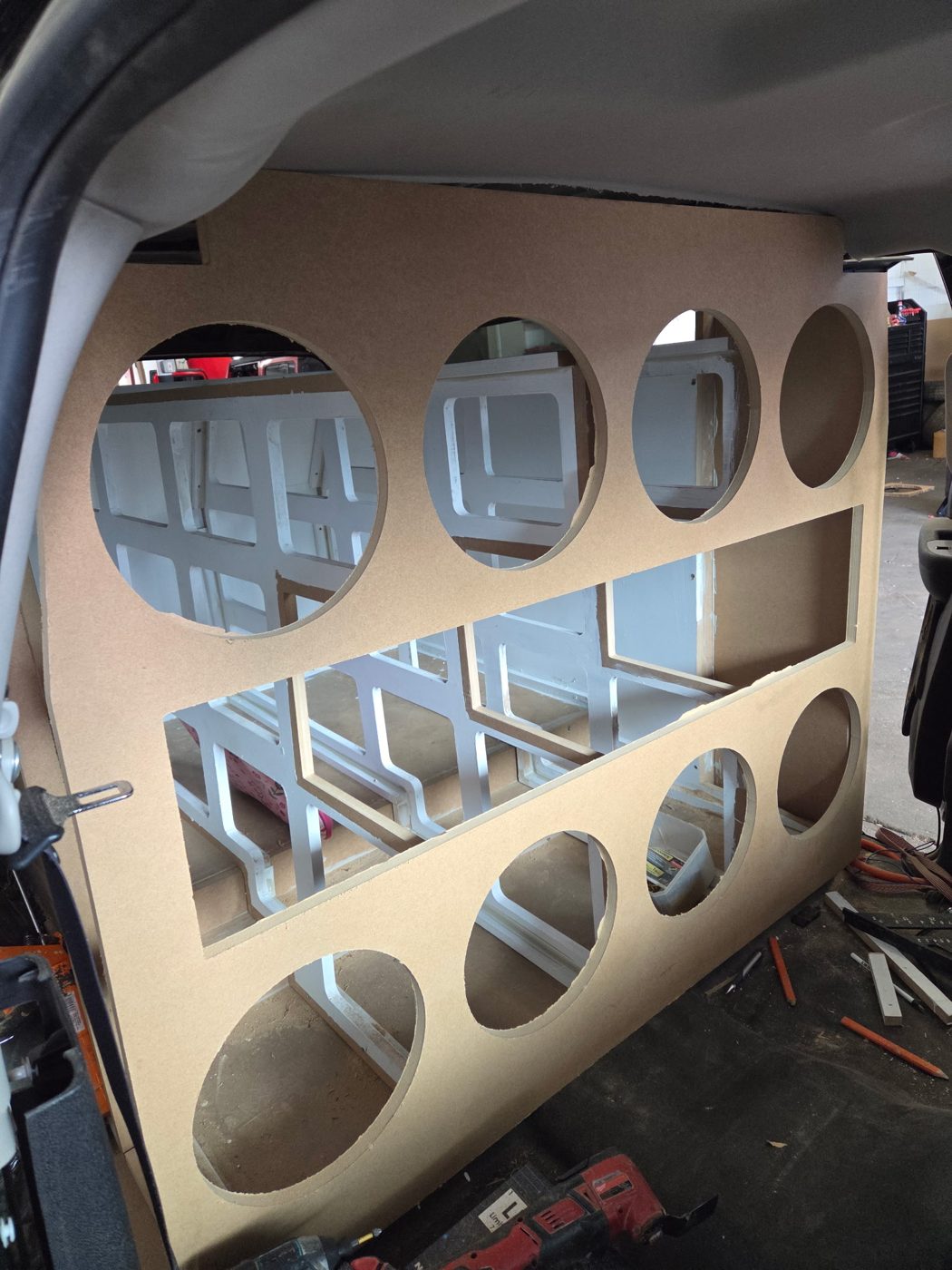MDF wall baffle with eight 12-inch subwoofer openings over the bracing